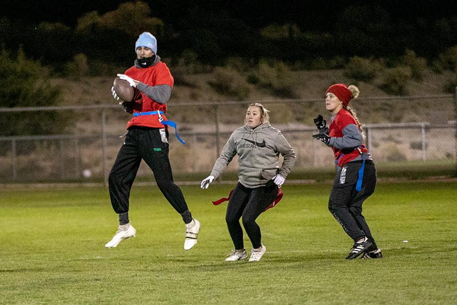 Three students playing football